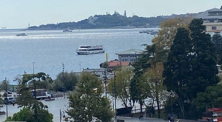 View of the Bosphorus near French Quarter Nails, İstanbul, TR, showcasing passing boats and scenic landscape.