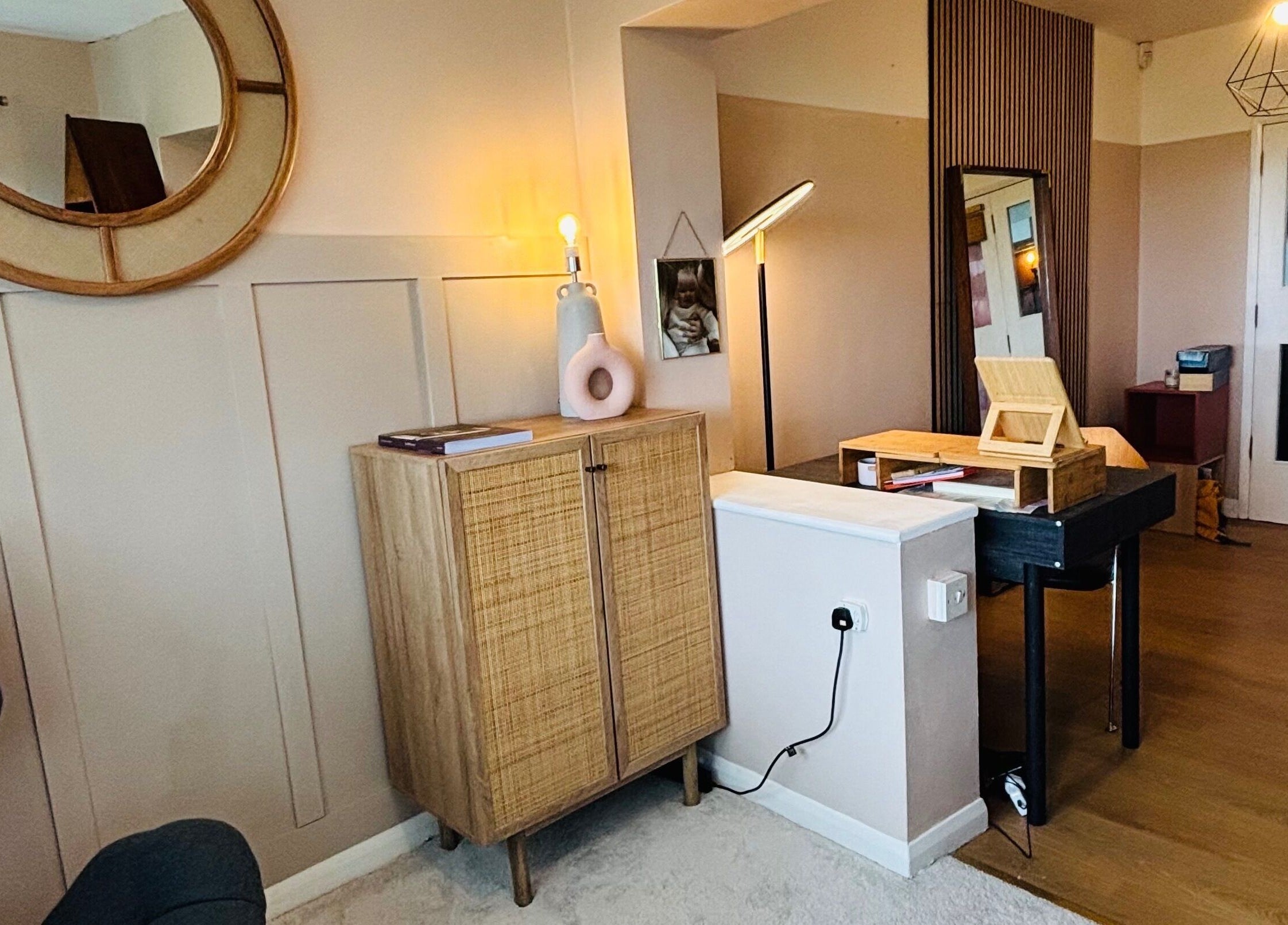 Stylish interior at Pristine Ink, Brentwood, England, GB, showcasing a chic mirror and wooden cabinet.