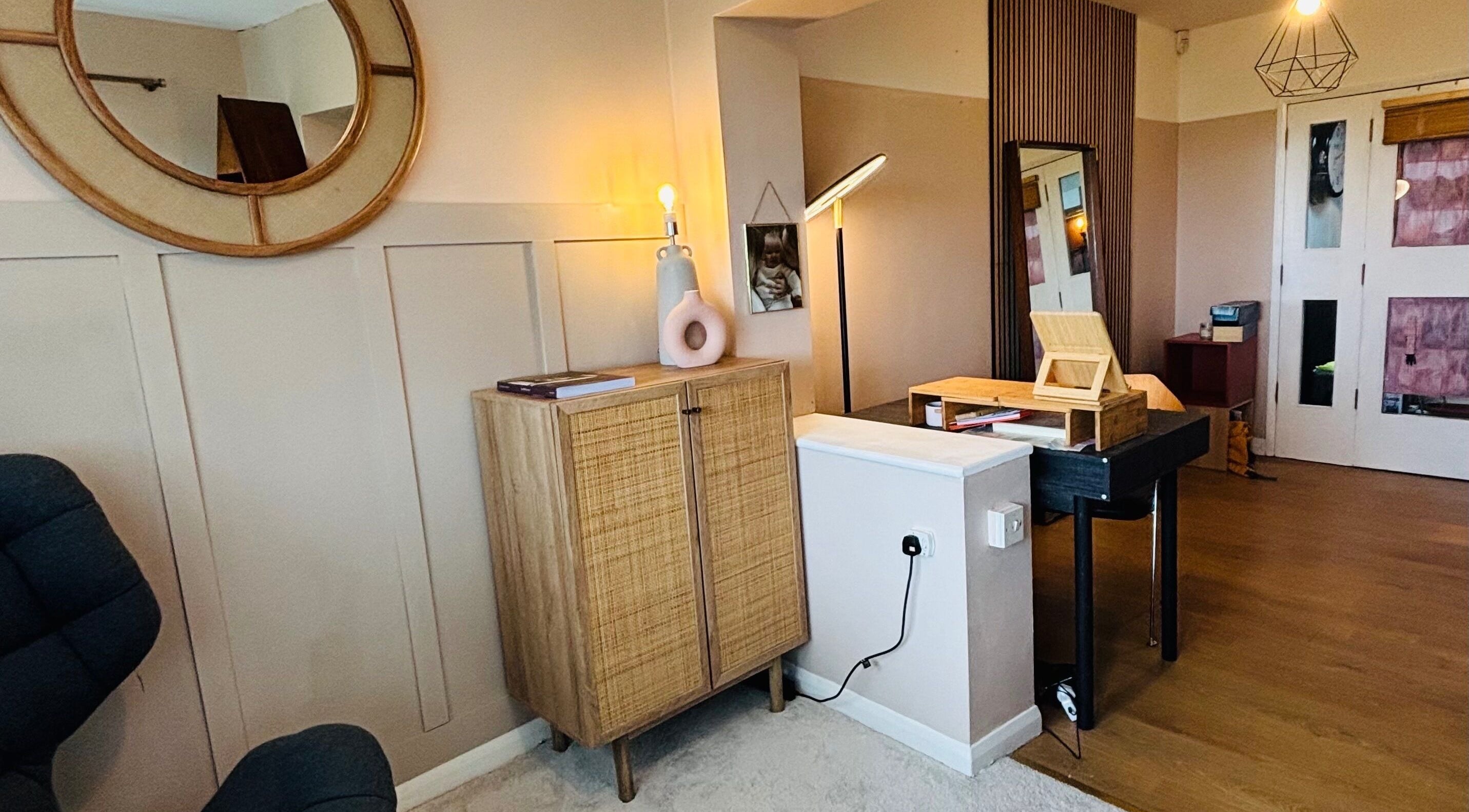 Stylish interior at Pristine Ink, Brentwood, England, GB, showcasing a chic mirror and wooden cabinet.