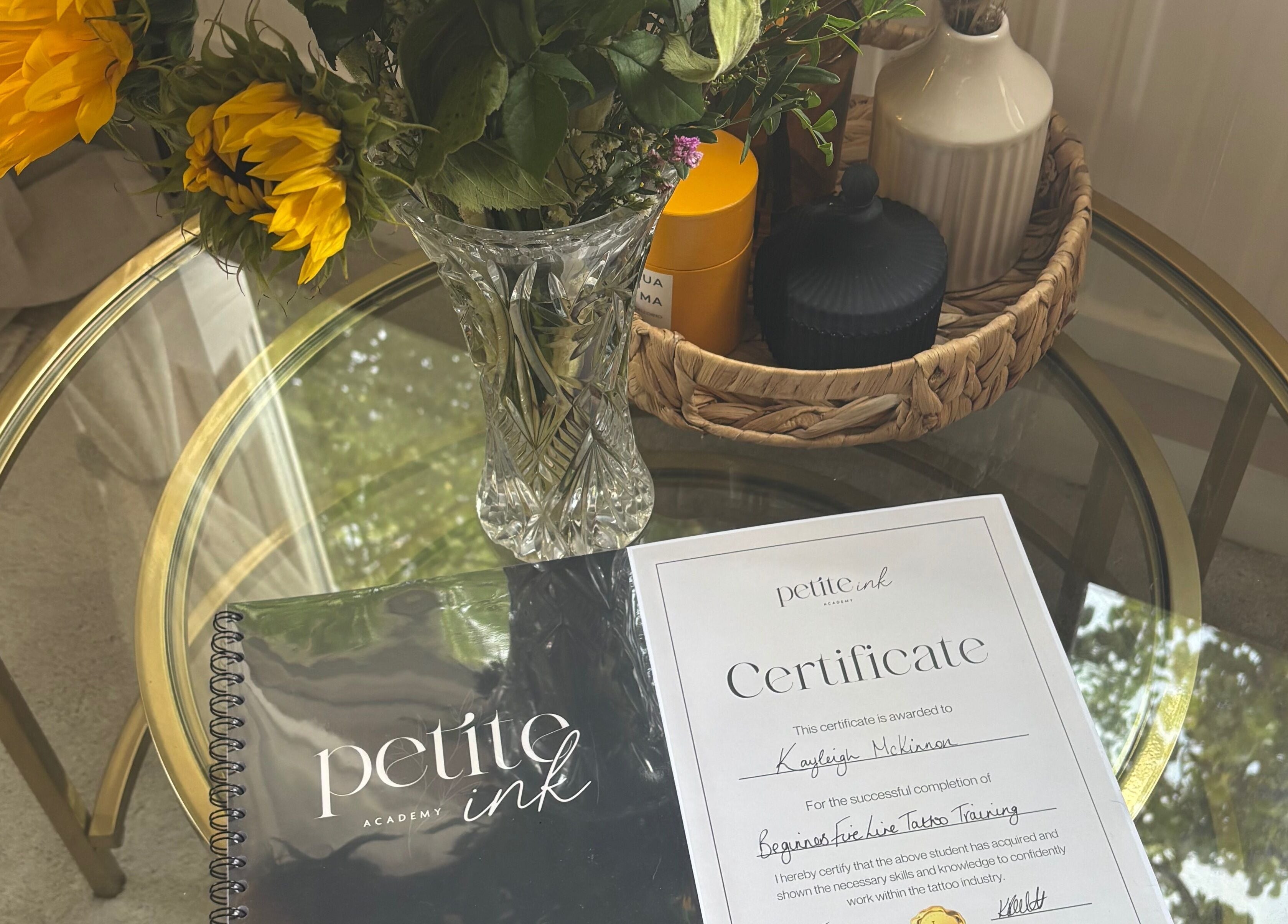 Certificate and flowers on table at Pristine Ink, Brentwood, England, GB. Celebrating tattoo training success.