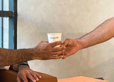 A customer receives a coffee cup at Capelli Boutique barbershop in Al Khobar, Eastern Province, SA.