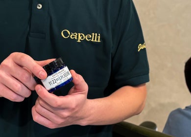 Staff at Capelli Boutique barbershop in Al Khobar holding a premium hair product.