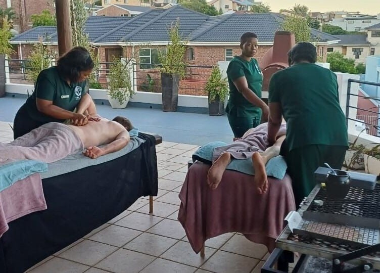 Massage session at Ubuhle Health and Wellness Spa, Jeffreys Bay, Eastern Cape, ZA, on a serene outdoor terrace.