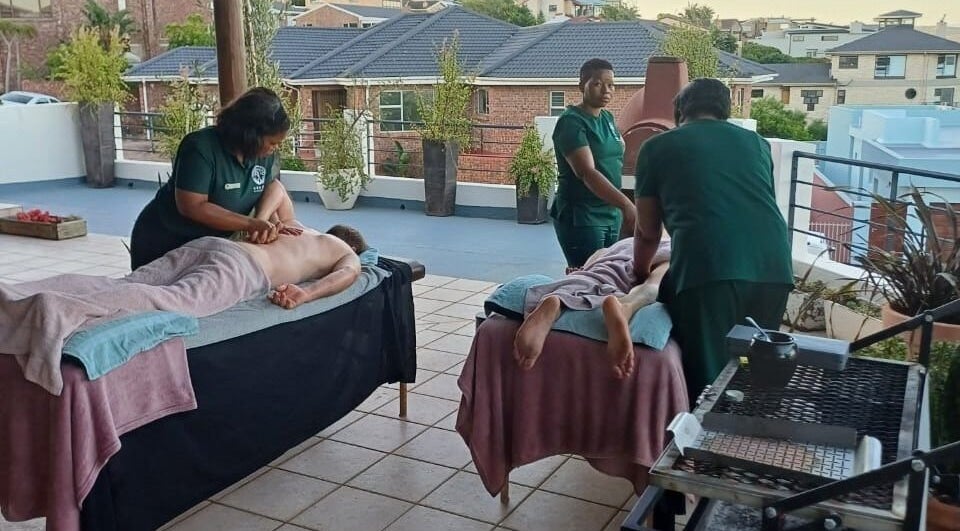 Massage session at Ubuhle Health and Wellness Spa, Jeffreys Bay, Eastern Cape, ZA, on a serene outdoor terrace.