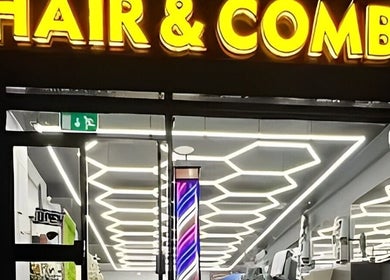 Hair & Comb salon exterior with neon sign in London, England, GB, showcasing modern interior design.