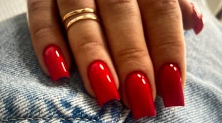 Red manicured nails on denim at Noran Beauty Academy, נוף הגליל, מחוז הצפון, IL.