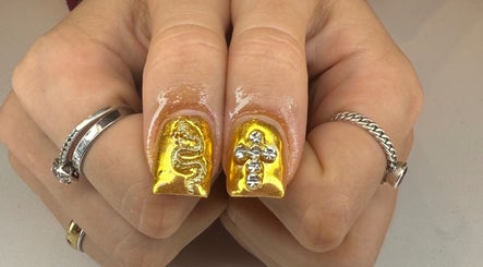 Elegant gold nails with snake and cross designs at Kpurenails, Cambridge, Waikato Region, NZ.