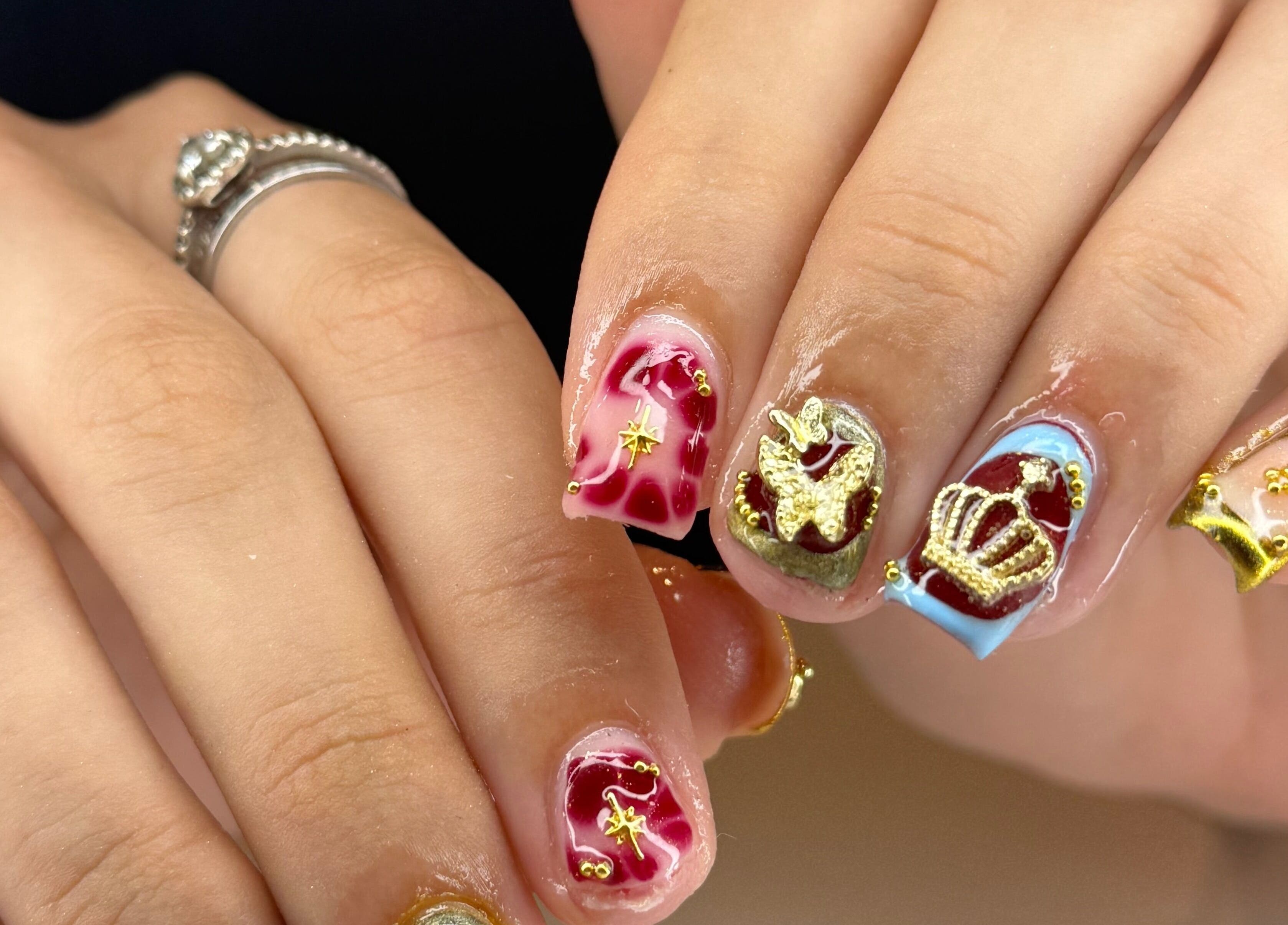 Intricate nail art with gold and maroon designs at Kpurenails, Cambridge, Waikato Region, NZ.