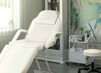 Relaxing spa treatment room with white chair at The Brilliance Bar, Olney, England, GB.