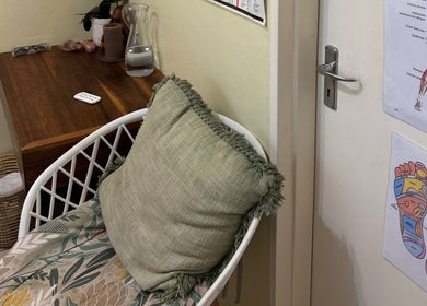 A calming therapy corner at Soulvae, Pietermaritzburg, Kwazulu-natal, ZA with a chair, cushions, and anatomy charts.