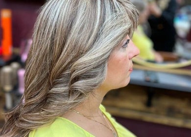 Stylish hairstyle with highlights at Persepolis Unisex Salon, London, England, GB. Elegant and modern look.