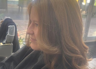 Woman with styled hair at maison de femme, Bristol, England, GB. Sunlight streaming in through windows.