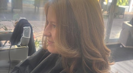 Woman with styled hair at maison de femme, Bristol, England, GB. Sunlight streaming in through windows.