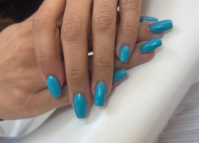 Bright blue nail polish on hands at Maison de Femme, Bristol, England, GB.