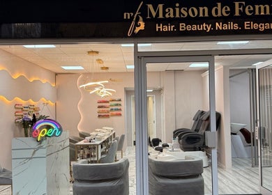 Entrance of Maison De Femme, a stylish beauty haven in Bristol, England, GB with a welcoming neon sign.