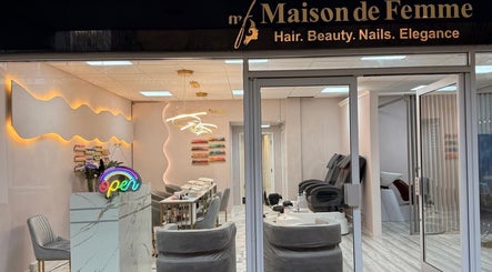 Entrance of Maison De Femme, a stylish beauty haven in Bristol, England, GB with a welcoming neon sign.