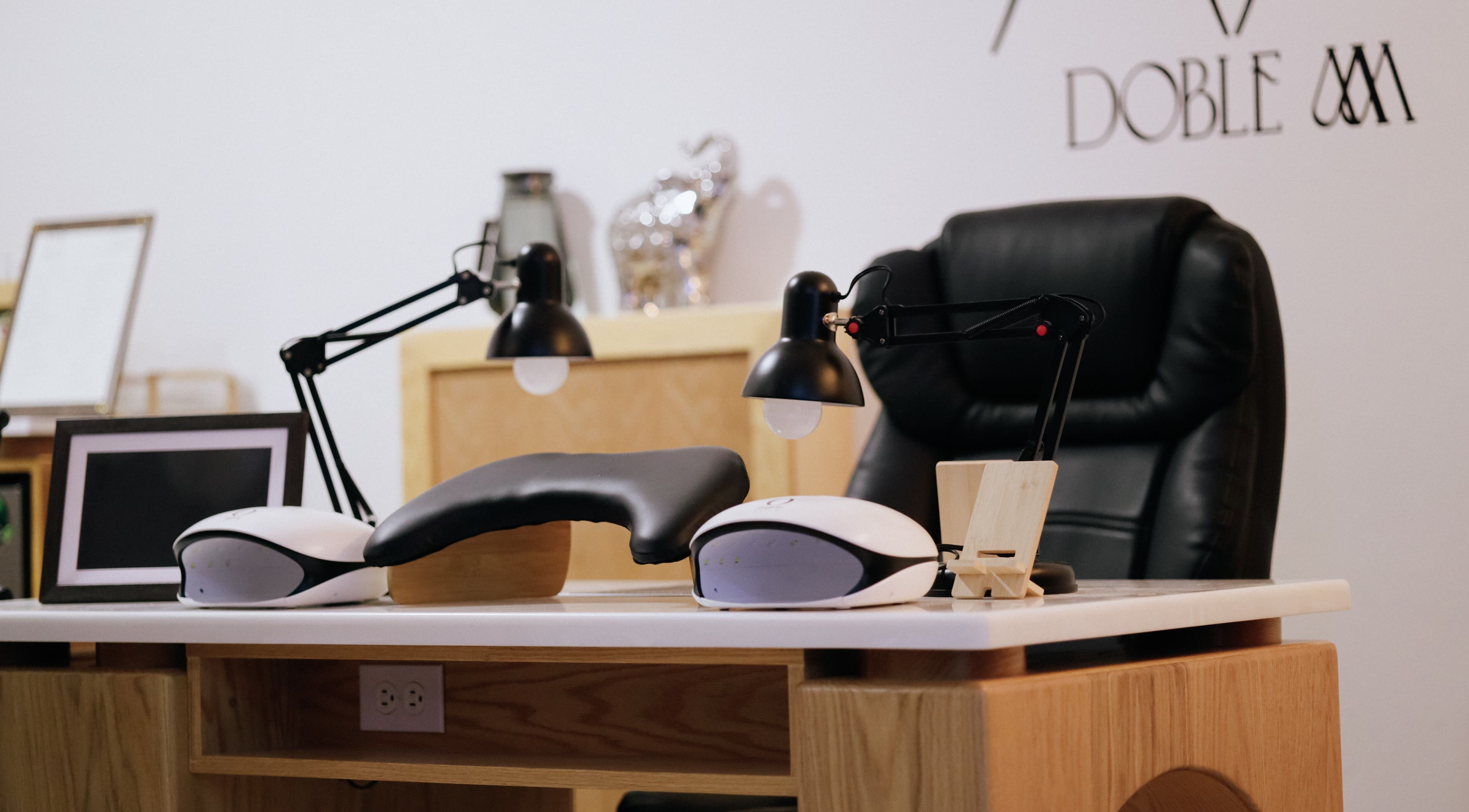 Mesa de manicura en Doble M Nails Studio en Matehuala, San Luis Potosí, MX, equipada con lámparas modernas.