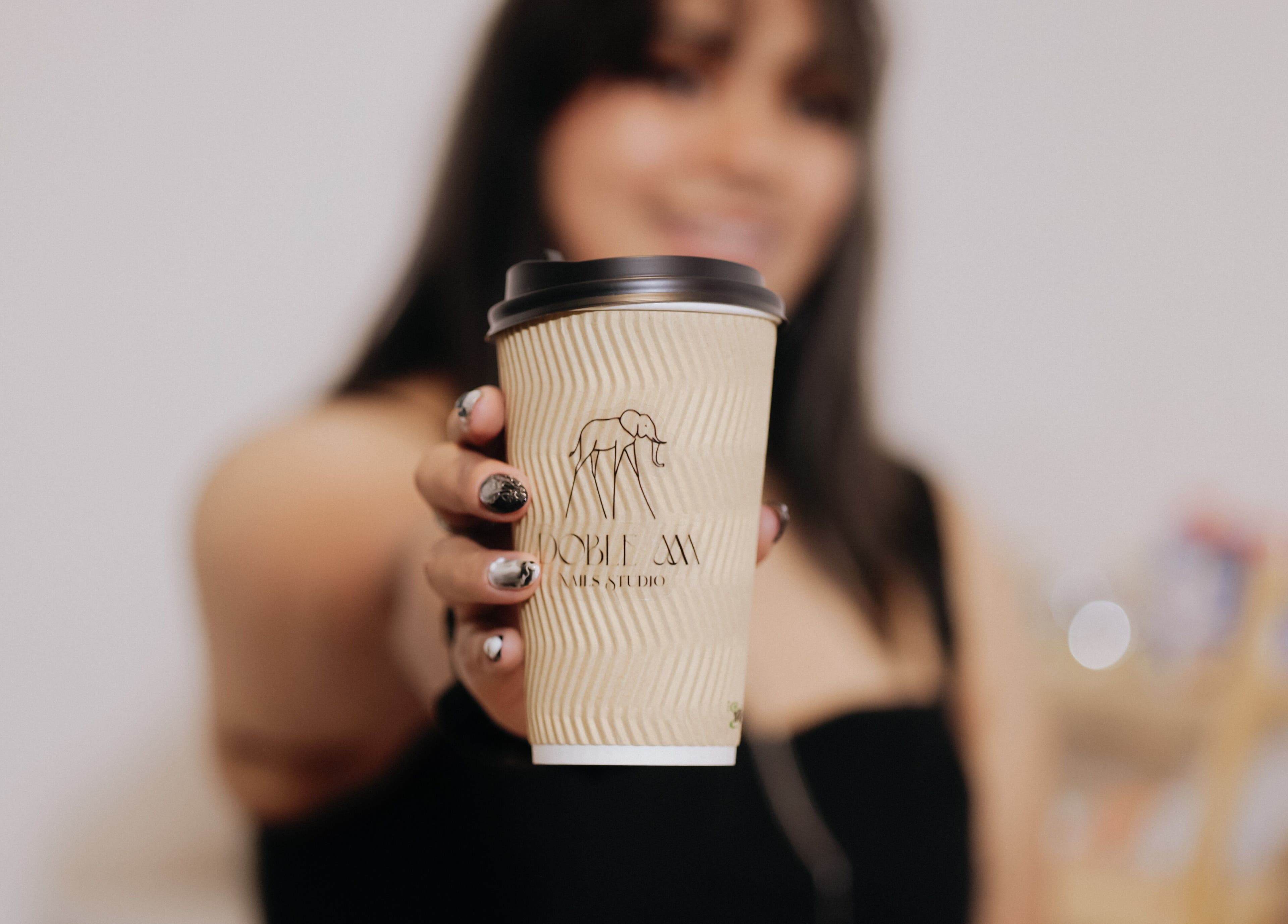 Cliente sosteniendo un vaso con logo de Doble M Nails Studio en Matehuala, San Luis Potosí, MX.