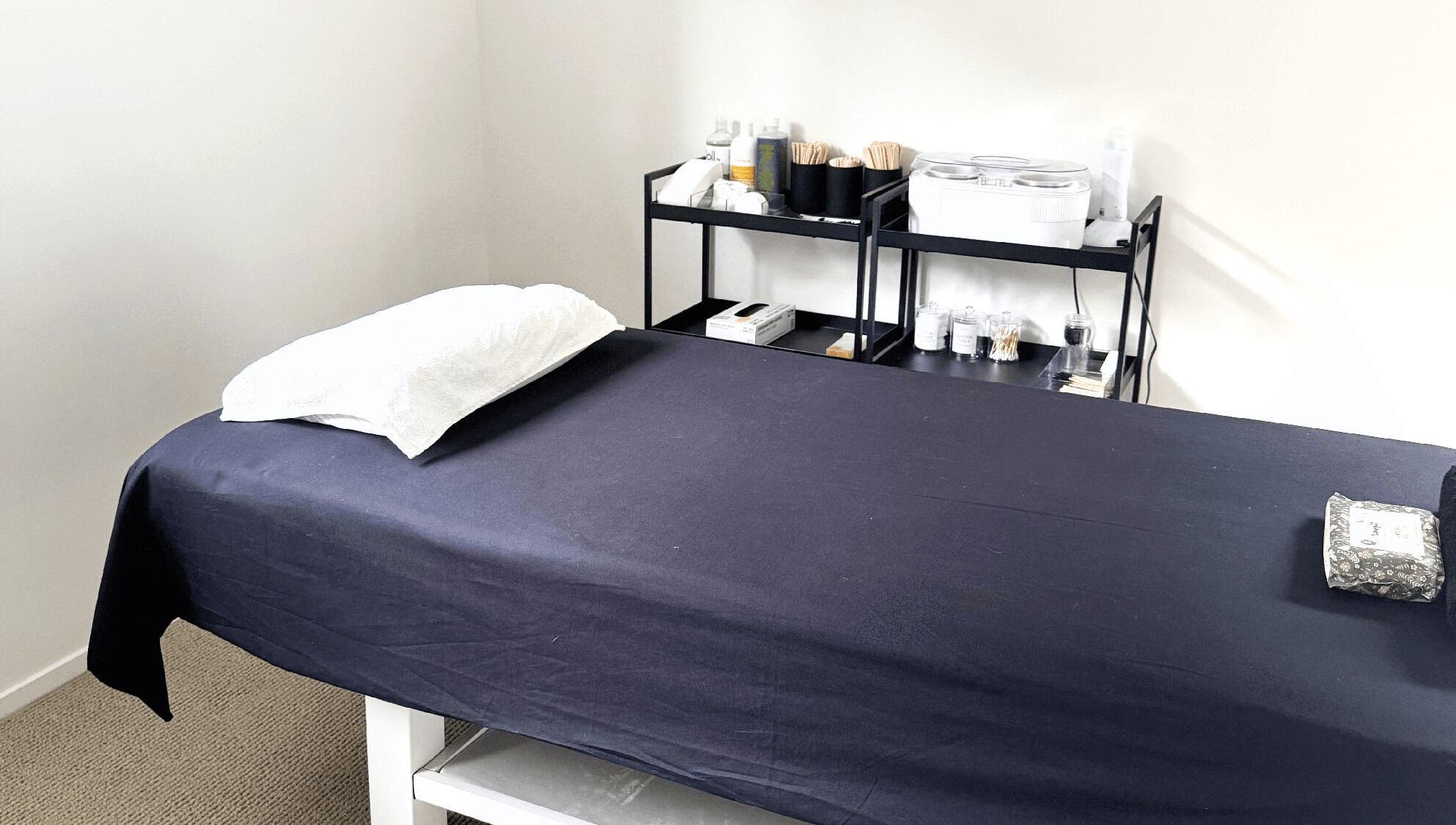 Massage room at All Things Me in Whangaparāoa, Auckland, NZ, featuring a treatment bed and relaxing ambiance.