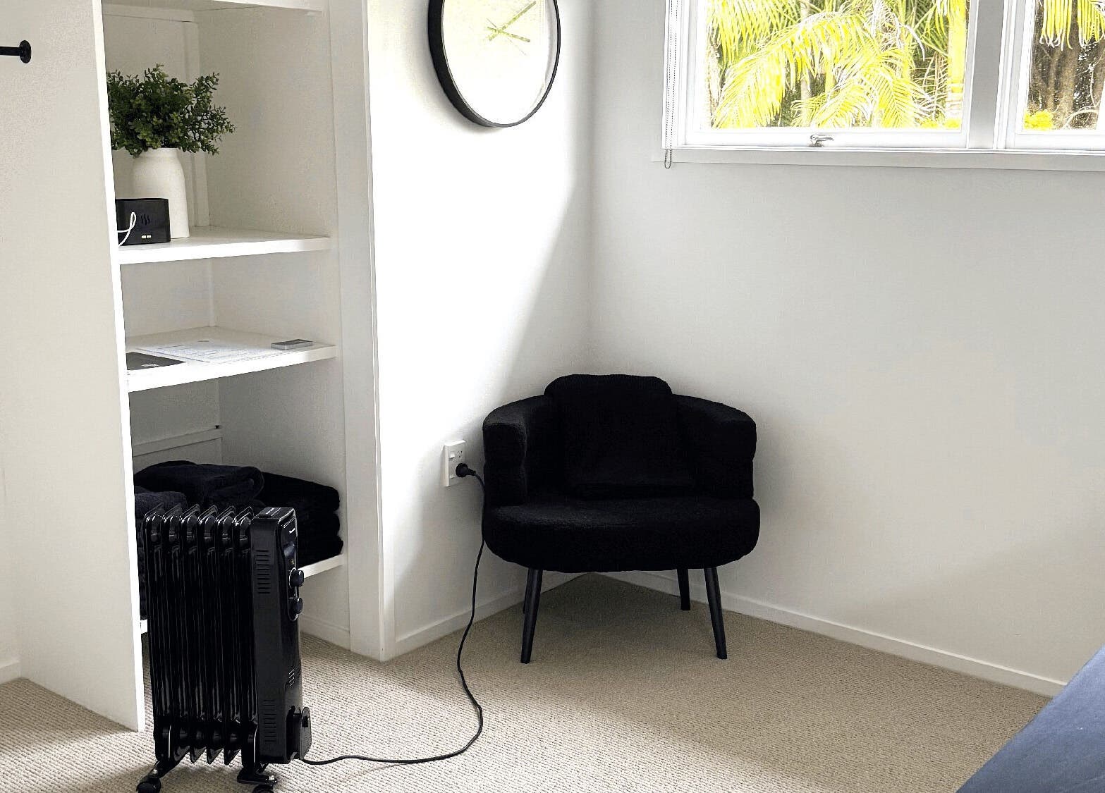 Relaxing black chair in a serene room at All Things Me, Whangaparāoa, Auckland, NZ.