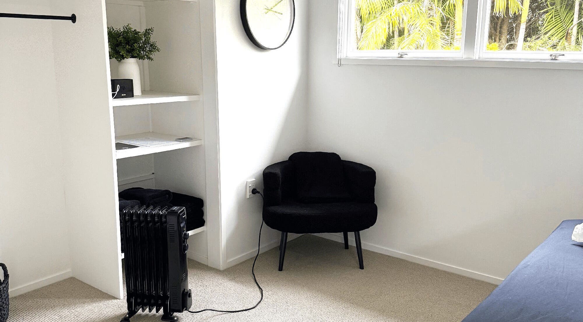 Relaxing black chair in a serene room at All Things Me, Whangaparāoa, Auckland, NZ.