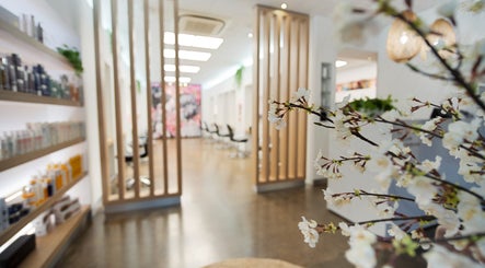 Elegant interior of Helmet Hair Studio in Darwin City with cherry blossoms and styling chairs.