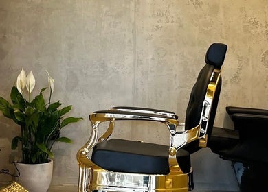 Luxurious barber chair at FANE BARBERSHOP, Jeddah, Makkah Province, SA with a soothing indoor plant.