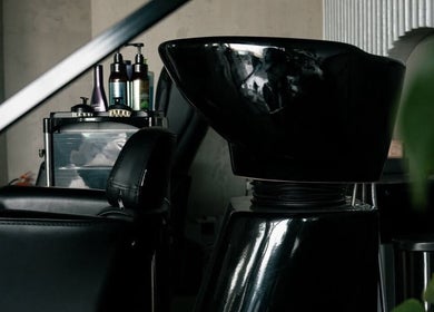 Elegant hair wash station at Fane Barbershop, Jeddah, Makkah Province, SA, featuring modern black furnishings.