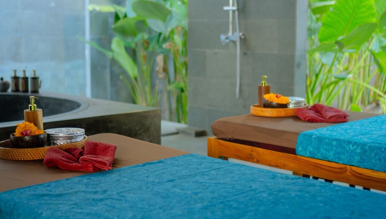 Ruang spa Soendaram Spa & Wellness Seaside Oceana di Bali dengan meja pijat nyaman dan dekorasi alami.