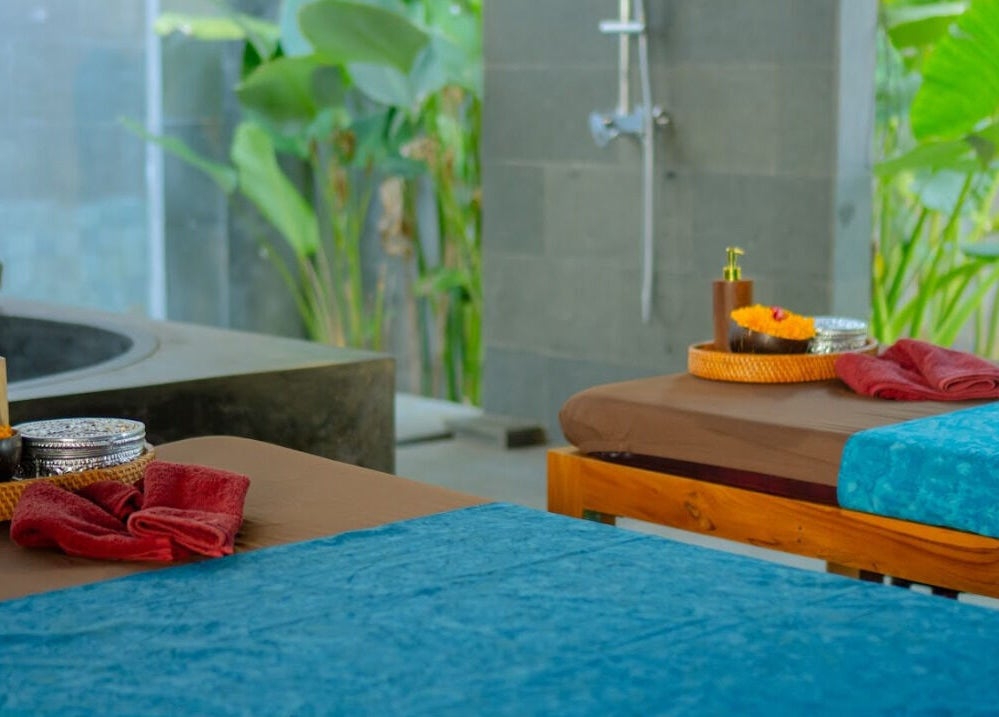 Ruang spa Soendaram Spa & Wellness Seaside Oceana di Bali dengan meja pijat nyaman dan dekorasi alami.