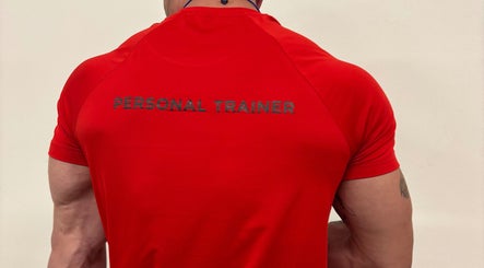 Back of personal trainer in red shirt at Zee Mania, Centurion, Gauteng, ZA.
