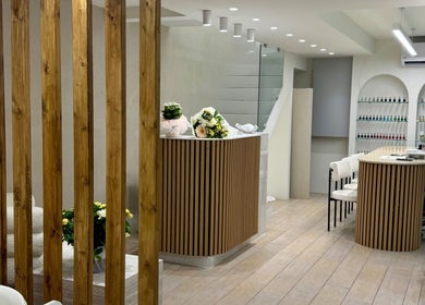 Κομψό εσωτερικό της Éclat Nails στη Γλυφάδα, GR με μίνιμαλ σχεδιασμό και ανθοδέσμες.