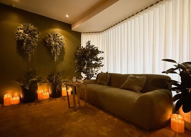 Cozy waiting area at Eden Massage Studio, East Perth, featuring lush plants and soft lighting for relaxation.