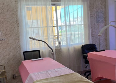 Sala de tratamiento en GURU LASH BROWS, Colonia Del Sol, Baja California Sur, MX con camas rosa y luz natural.