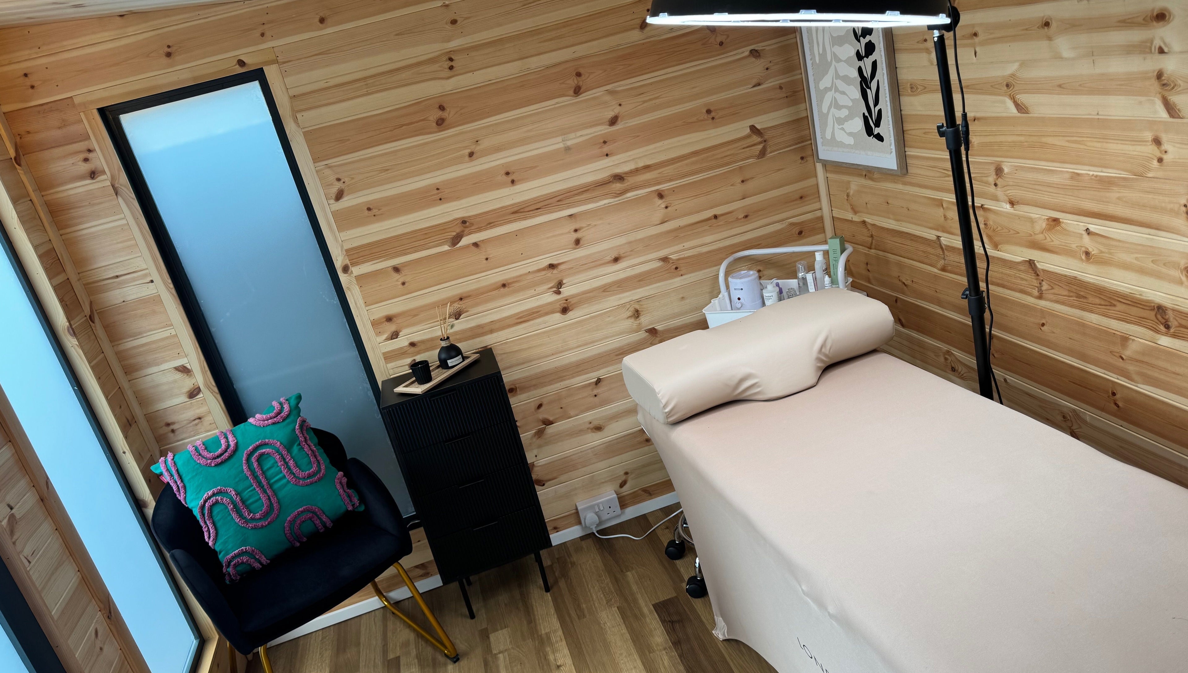 Cozy treatment room at H L Beauty in Poringland, England, GB, featuring a wooden decor and comfortable setup.