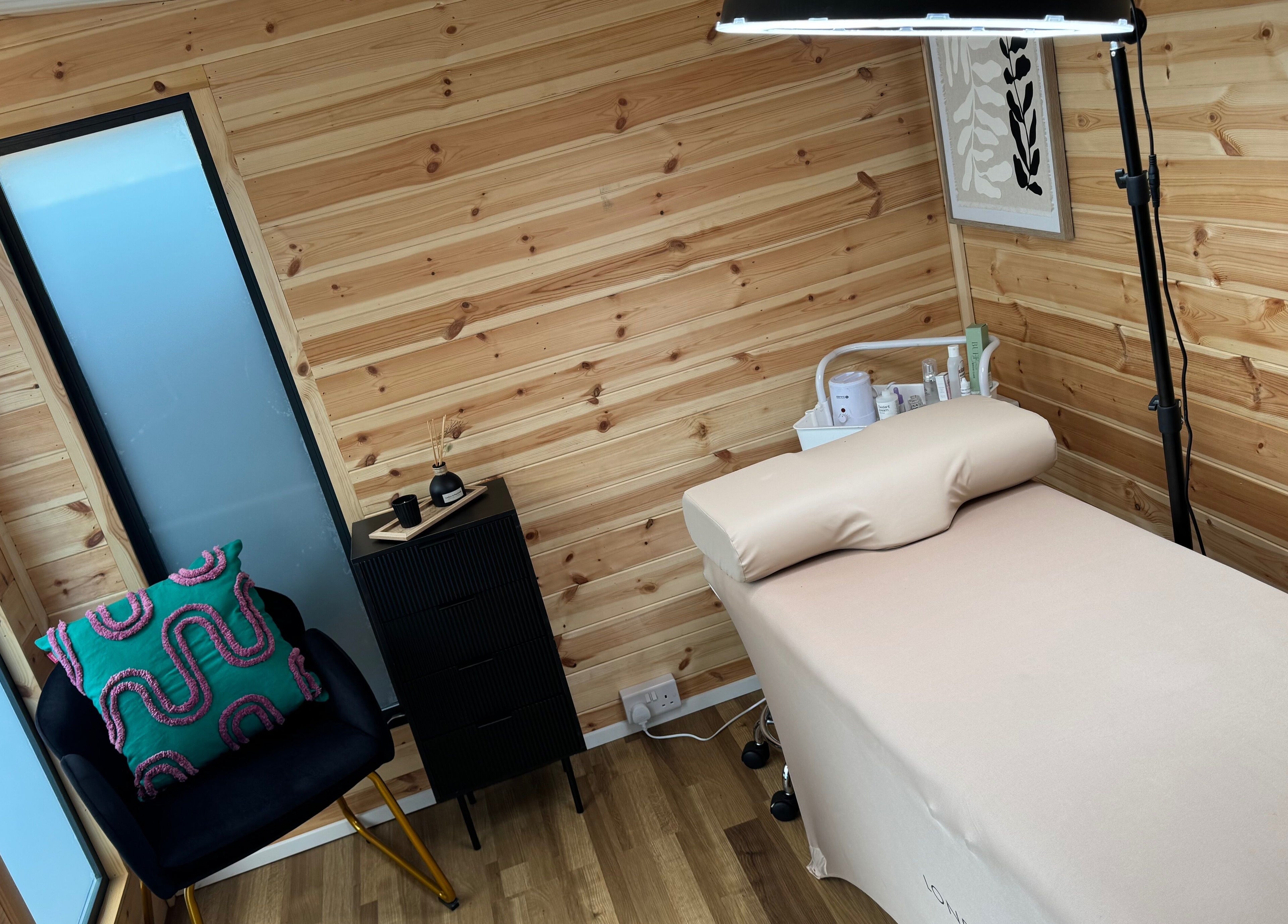 Cozy treatment room at H L Beauty in Poringland, England, GB, featuring a wooden decor and comfortable setup.