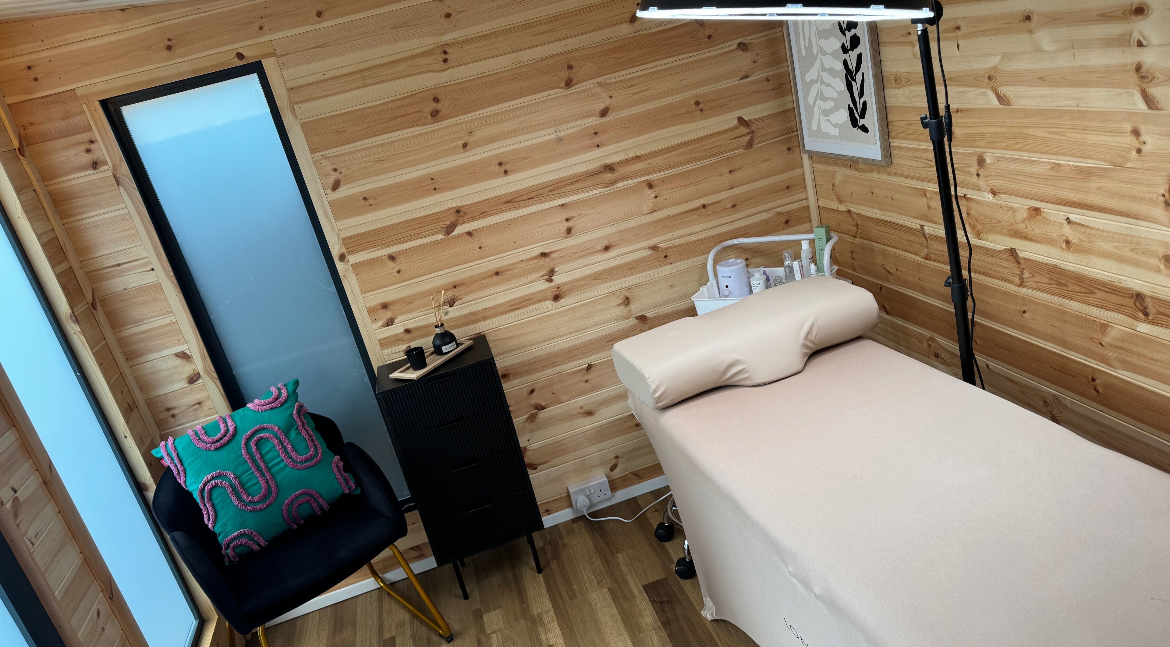 Cozy treatment room at H L Beauty in Poringland, England, GB, featuring a wooden decor and comfortable setup.