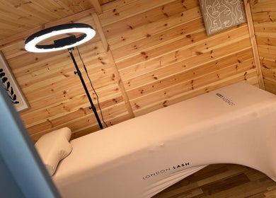 Tranquil treatment room at H L Beauty in Poringland, England, GB with wooden walls and massage table.