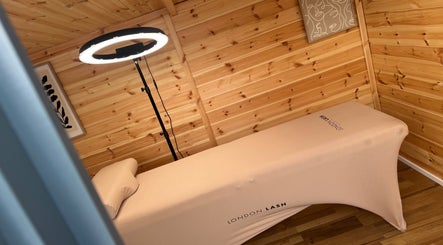 Tranquil treatment room at H L Beauty in Poringland, England, GB with wooden walls and massage table.