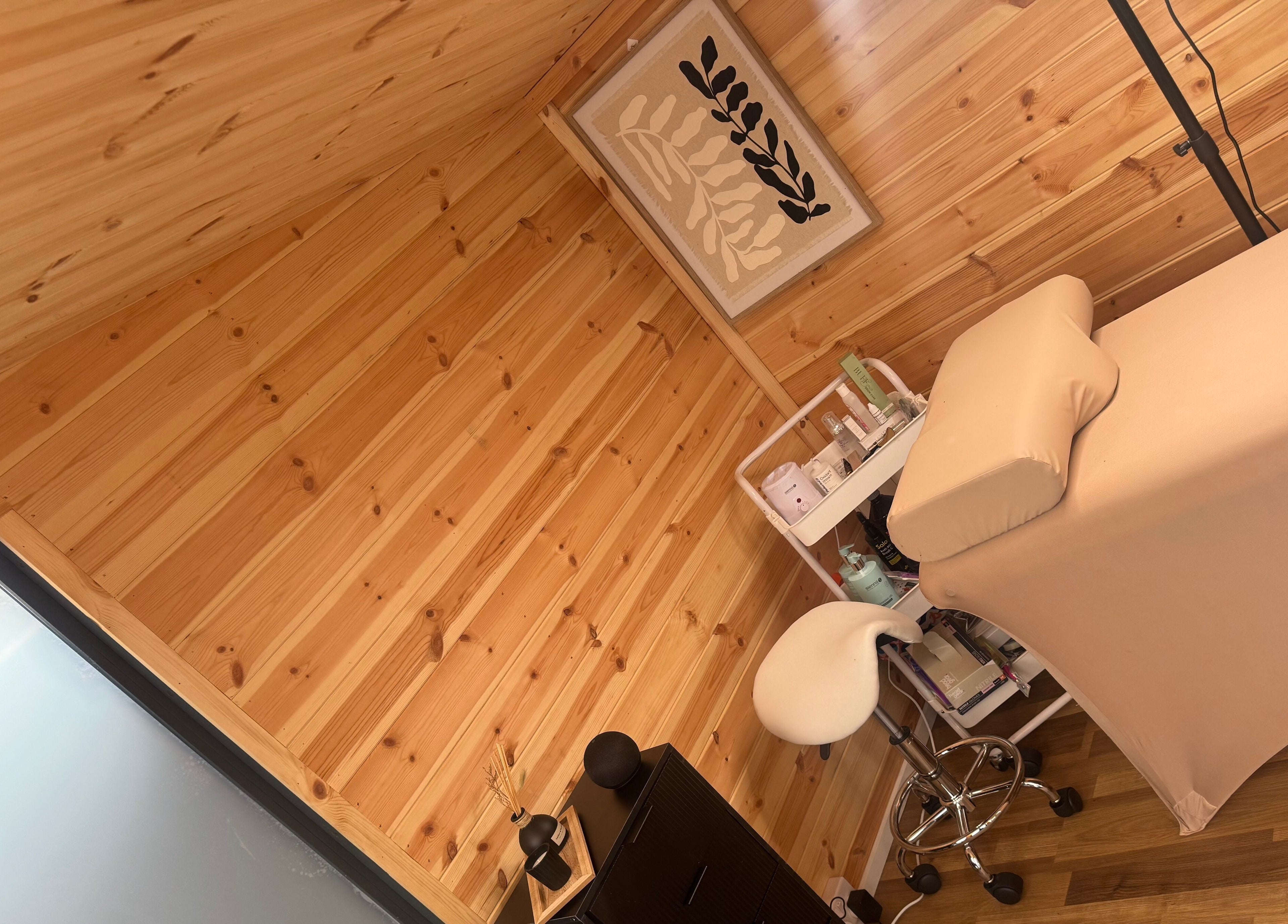 Relaxing treatment room at H L Beauty, Poringland, England, GB, featuring a cozy massage table and calming decor.