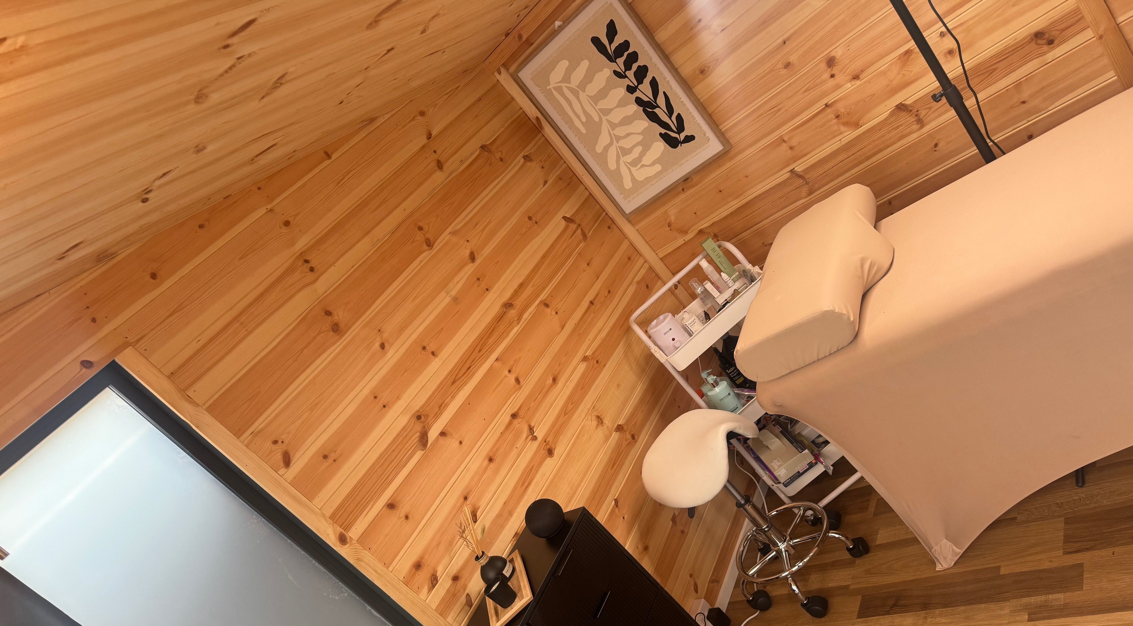 Relaxing treatment room at H L Beauty, Poringland, England, GB, featuring a cozy massage table and calming decor.