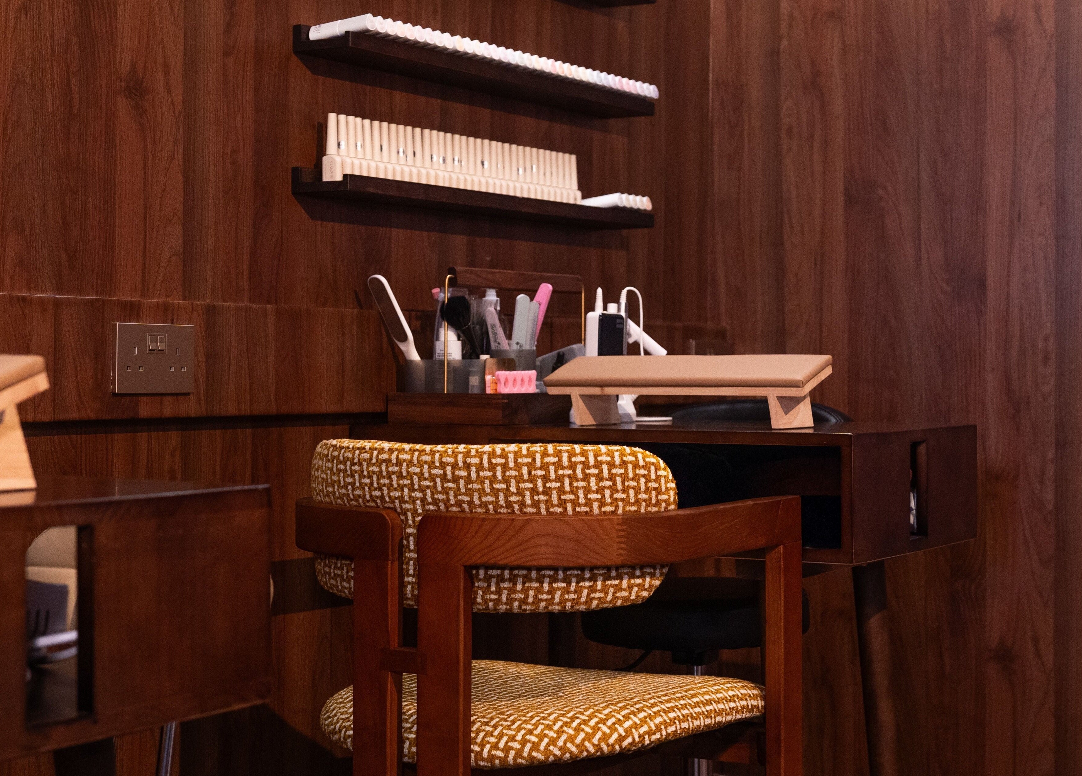 Elegant manicure station at Cupid's Club, Singapore, Singapore, SG with wooden decor and plush seating.