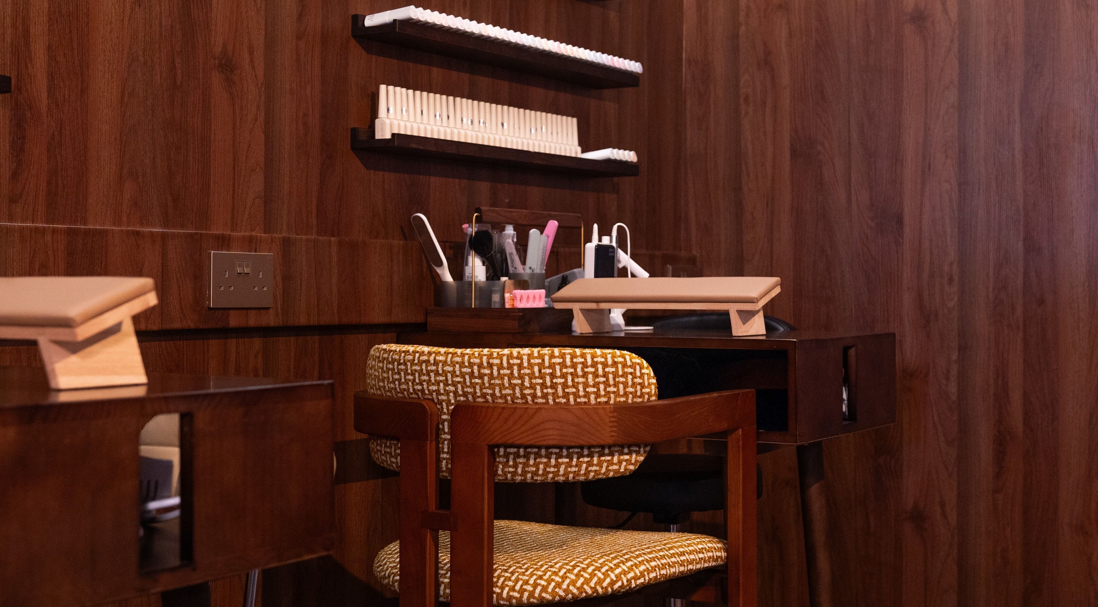 Elegant manicure station at Cupid's Club, Singapore, Singapore, SG with wooden decor and plush seating.