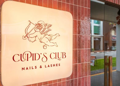Entrance sign of Cupid's Club Nails & Lashes in Singapore, Singapore, SG with elegant design on red tiles.