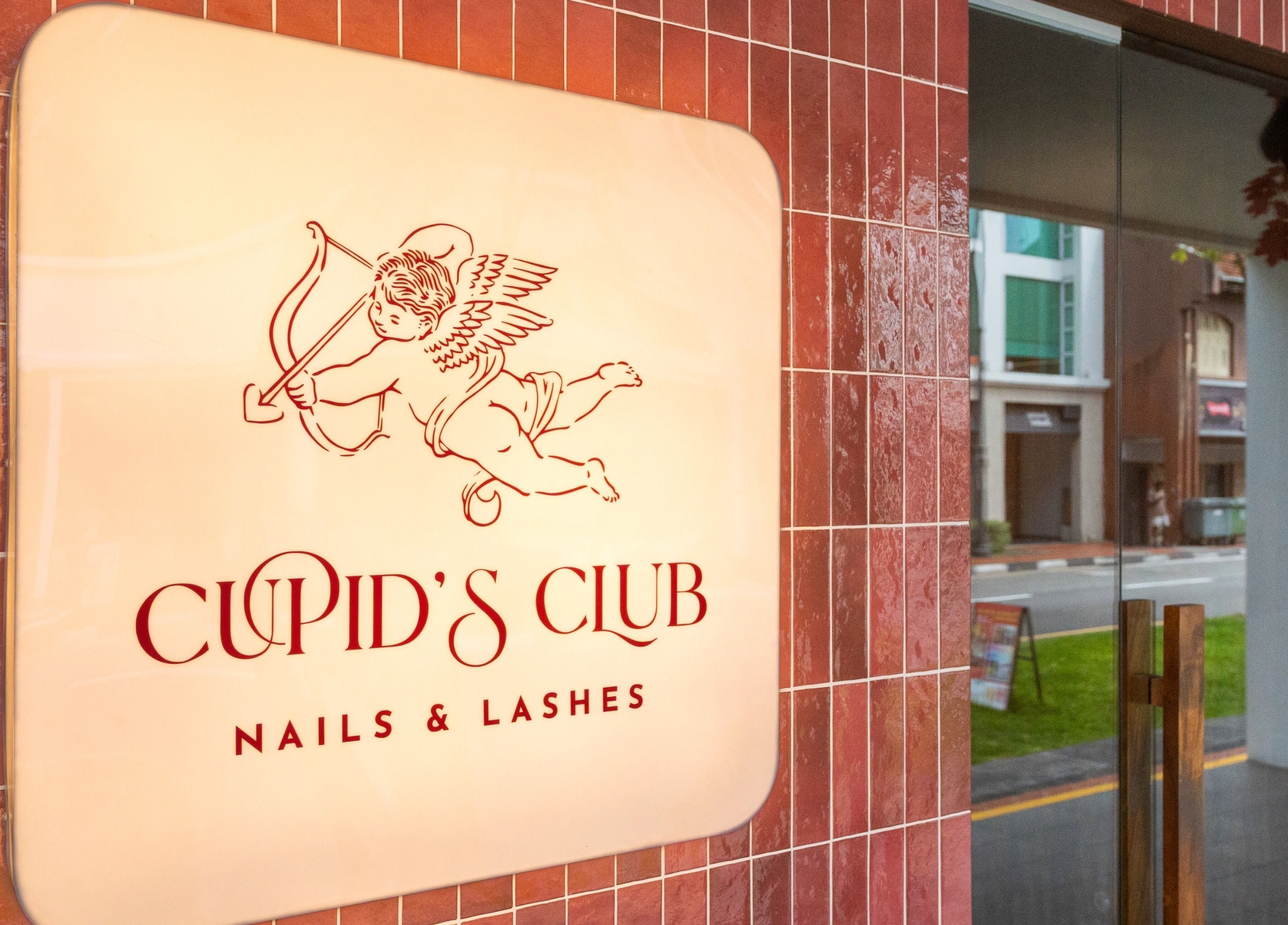 Entrance sign of Cupid's Club Nails & Lashes in Singapore, Singapore, SG with elegant design on red tiles.