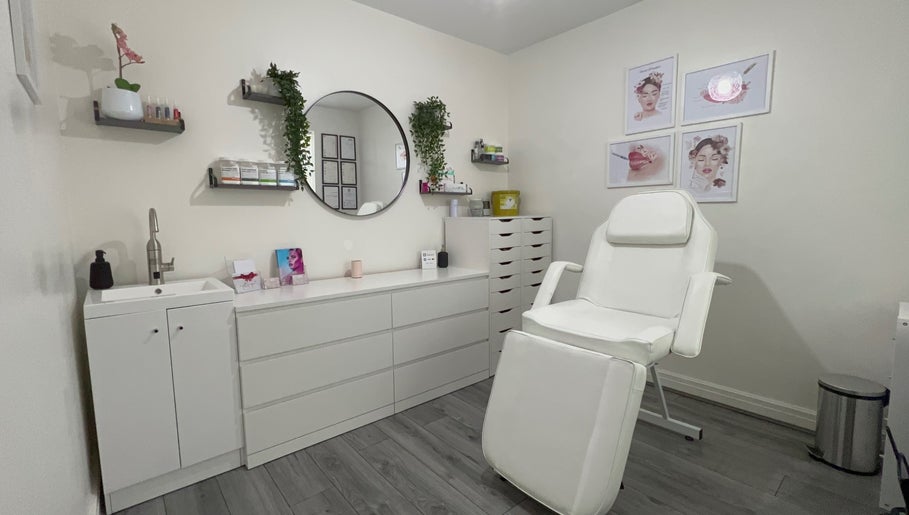 Relaxing treatment room at Lash & Line Studio, Wigan, England, GB with white decor and comfortable chair.