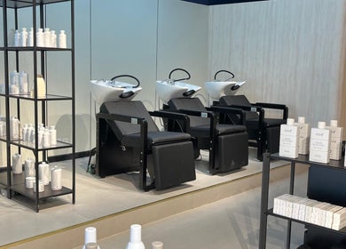 Modern salon interior at Hairchef & Dociä Salon LLC, Dubai, AE with washing stations and product shelves.