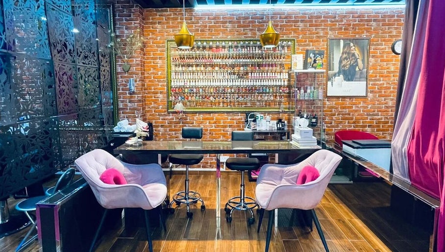 Interior of Pink Blink The Beauty Lounge in Dubai, AE showcasing stylish seating and vibrant nail polish display.