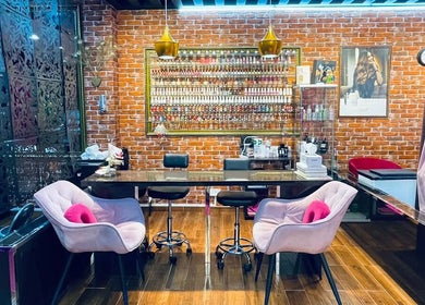 Interior of Pink Blink The Beauty Lounge in Dubai, AE showcasing stylish seating and vibrant nail polish display.