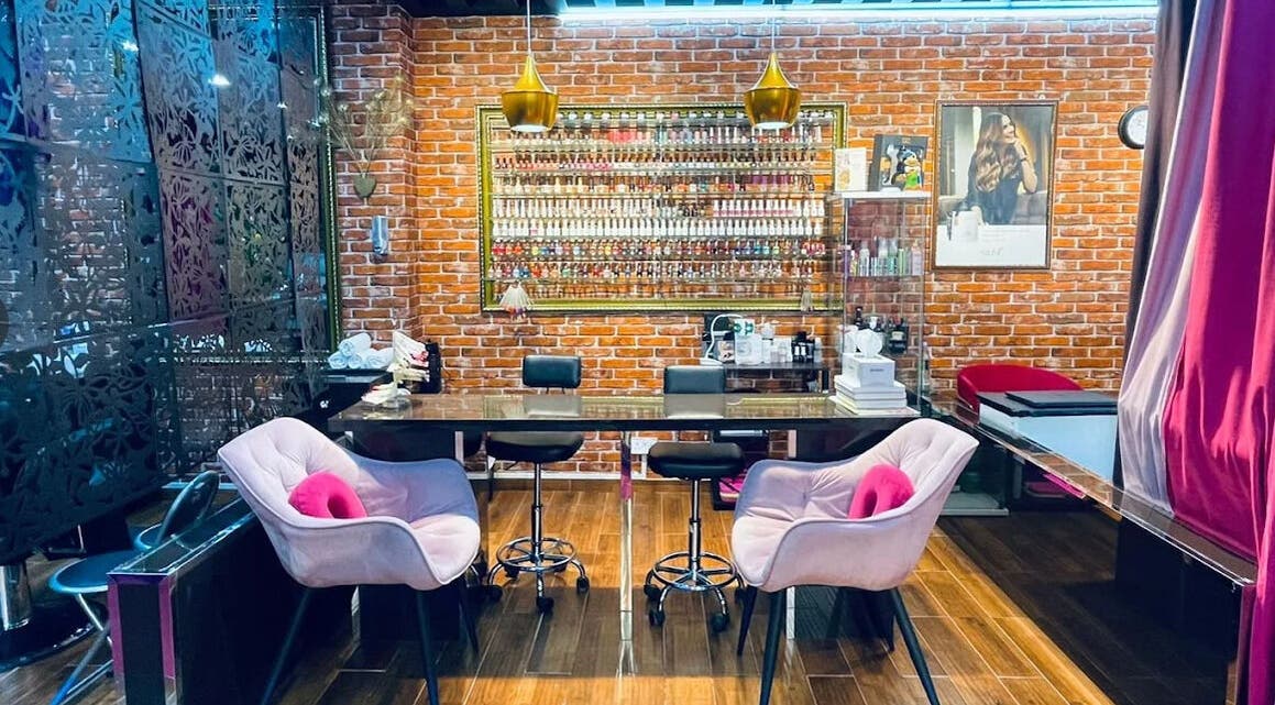 Interior of Pink Blink The Beauty Lounge in Dubai, AE showcasing stylish seating and vibrant nail polish display.